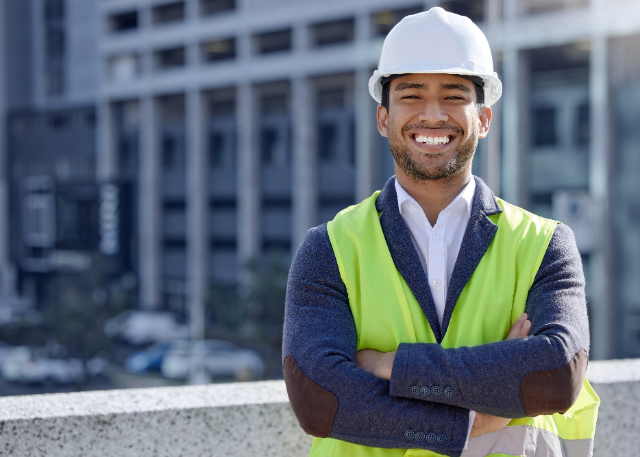 Man in hard hat with building behind him