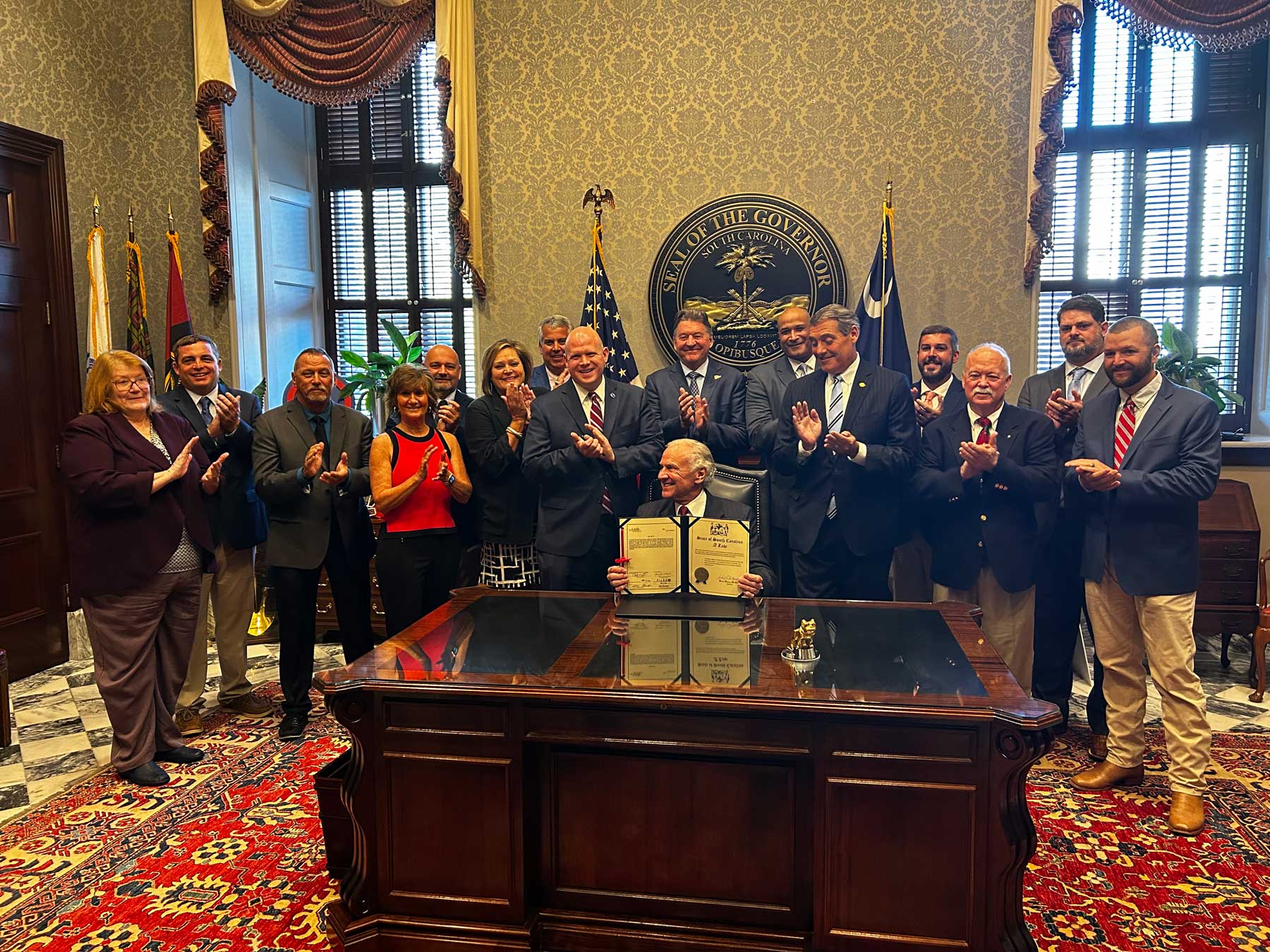 Spectators applaud as Governor McMaster signs the bill